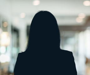 Russell-Cooke Solicitors staff photograph. Silhouette of a female team member against the backdrop of an office with a soft focus effect.