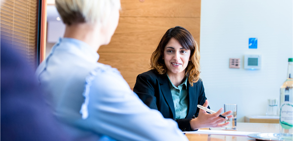 Graduate with team in a meeting room discussing legal topic