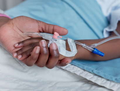 Mother holding the hands of a small child with an IV drip. Infectious diseases and sepsis claims for children.