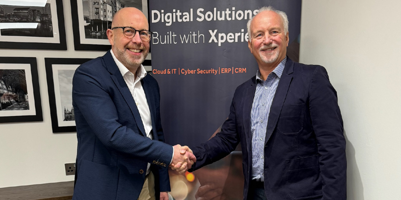 Iain O'Kane and Chris Harthman shake hands on a deal on the sale of GCC Group to Xperience. 