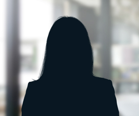 Russell-Cooke Solicitors staff photograph. Silhouette of a female team member against the backdrop of an office window with a soft focus effect.
