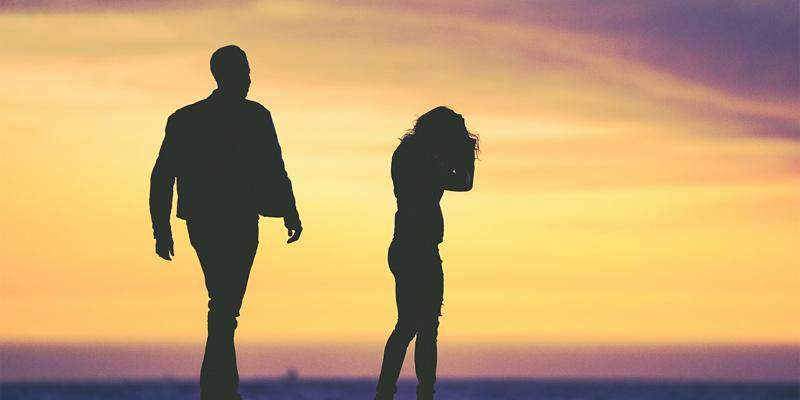 A male and female silhouette appearing to be arguing in front of a sunset. ‘How has my ex-husband ended up living off me for the rest of his life?’—The Telegraph