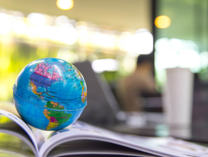 Miniature globe placed on an open textbook | Russell-Cooke charity law and nonprofits team helping charities and nonprofits navigate the legal and regulatory challenges of working internationally