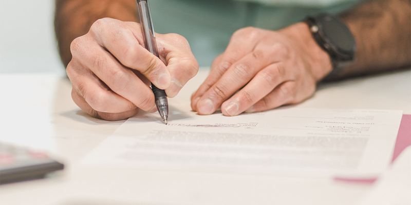 man signing paperwork. Future general election and the impact on IHT - inheritance tax.