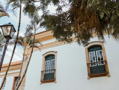 Exterior facing wall of Spanish house showing windows and branches of trees
