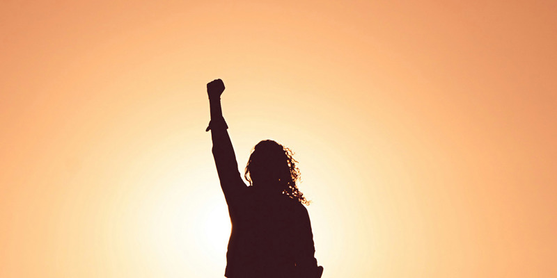 A female silhouette punching her fist in the air in the sun. Equality in practice: what does it look like to work at Russell-Cooke on IWD in 2024?