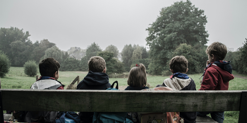 children sitting on a bench in the countryside. family-court-transparency-pilot-russell-cooke-news-2023