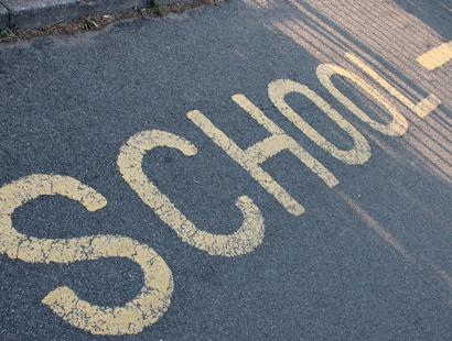 Road marking with the words 'School' in yellow. Judicial review and LGSCO complaints with local authorities