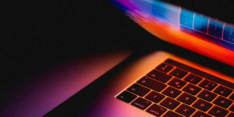 An illuminated laptop screen in a dark room. How the Online Safety Act 2023 shapes the future of online services