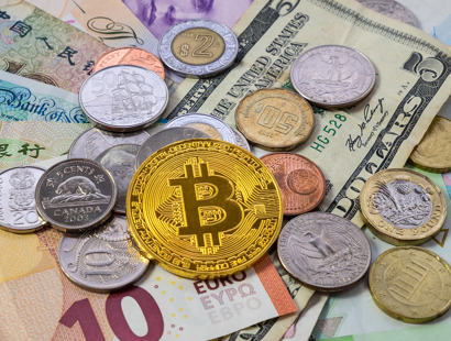 An array of fiat currencies including Euros, Dollars, Pound Sterling alongside a Bitcoin representative coin. Financial crime solicitors.