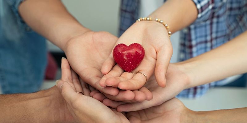 group of hands holding a heart